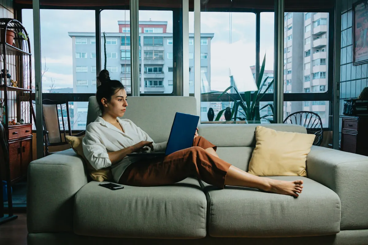 Mujer joven respirando con calma junto a una ventana